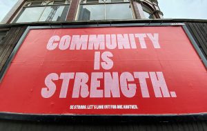 Coca Cola Billboard with the message Community is Strength. Be strong, let's look out for one another.